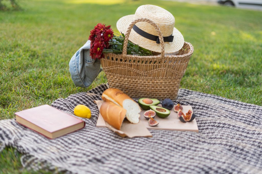 picnic basket on a picnic rug with food